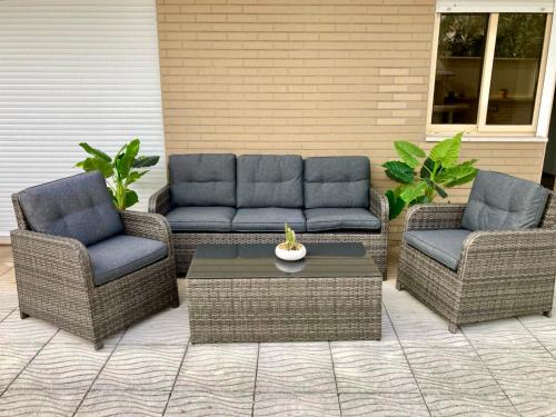 two wicker chairs and a coffee table on a patio at Rocha’s Apartment REMODELADO! Na praia com terraço in Vila Nova de Gaia