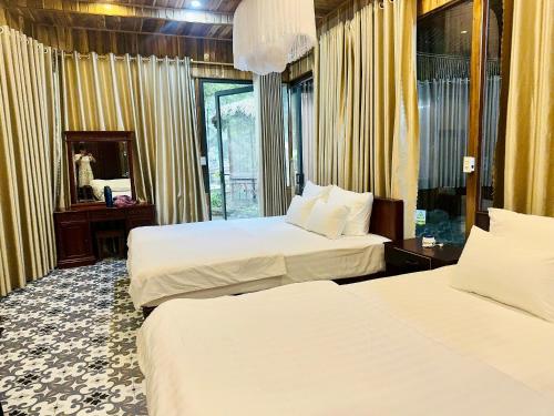 a hotel room with two beds and a mirror at Mua Caves Ecolodge (Hang Mua) in Ninh Binh