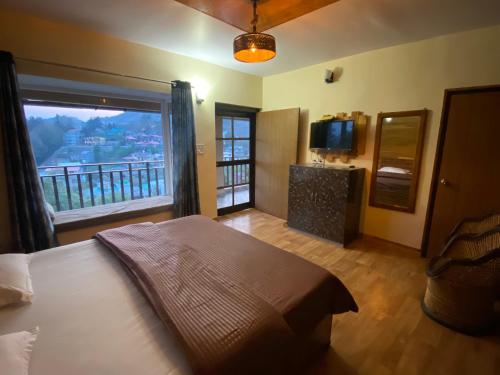 1 dormitorio con cama y ventana grande en Khushi Cottage en Mukteswar