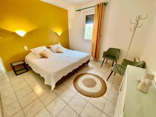 ヴィルヌーヴ・ド・ベルグにあるGITE avec JACUZZI PRIVATIF 4 étoiles 90m2 pour 3 personnesのベッドルーム1室(ベッド1台、緑の椅子付)