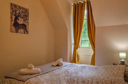 une chambre avec un lit avec deux animaux en peluche dessus dans l'établissement Logement Alice Wilson, à Mont-sous-Vaudrey