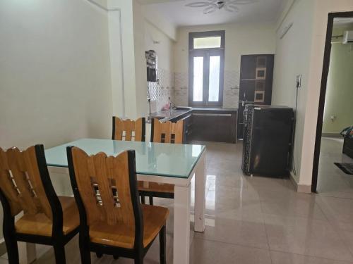 a kitchen with a table and chairs and a kitchen with a refrigerator at 3 BHK in Krishna Nagar Lucknow LKO 202R in Lucknow