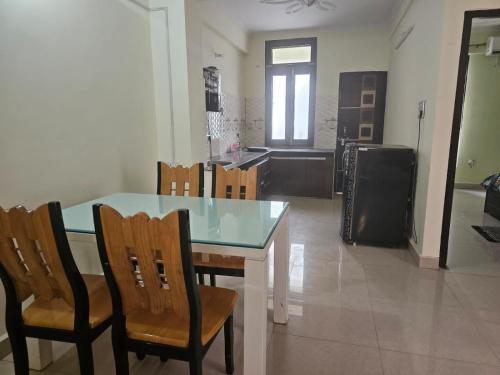 a kitchen with a table and chairs and a kitchen with a refrigerator at 3 BHK in Krishna Nagar Lucknow LKO 202R in Lucknow