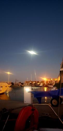 a view of a harbor at night with a light at Nuit insolite Bateau 11 mètres in Le Barcarès