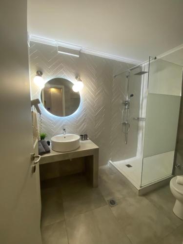 a bathroom with a sink and a shower and a mirror at Villa Pantheon in Litochoro