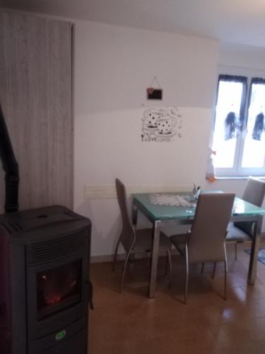 a dining room with a table and a stove at Appartamento Caterina in Cairo Montenotte