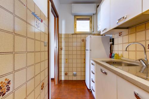 托爾托雷托的住宿－Appartamento Vespucci Trilo Plus - MyHo Casa，一间带水槽和冰箱的小厨房