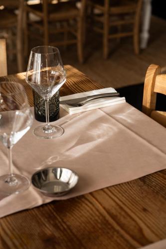 a wooden table with two wine glasses and a napkin at Camoma Aparthotel - Suites Apartments in Jesolo
