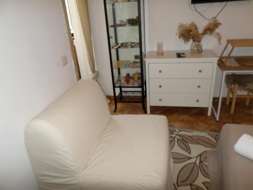 a living room with a white couch and a dresser at Vichome in Catania