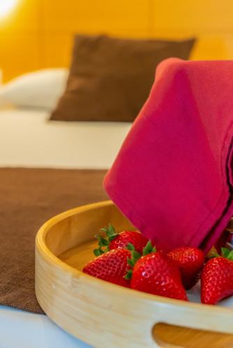 a wooden bowl of strawberries with a pink napkin at La City Estación in Alicante