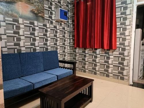 a living room with a blue couch and red curtains at Rudra Villas in Rāmeswaram