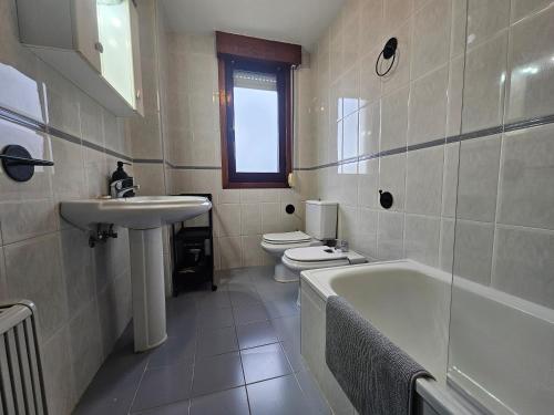 y baño con 2 aseos, bañera y lavamanos. en Apartamento Ría Navia El Espín 31A01, en Navia