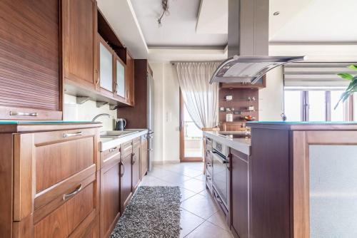 a large kitchen with wooden cabinets and a stove at Vacation House close to the Beach in Elia