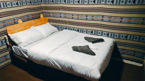 ein Bett mit zwei Paar Schuhen drauf in der Unterkunft Dana WhiteDometrail Lodge in Dana