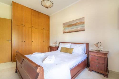a bedroom with a large bed and a wooden cabinet at Vacation House close to the Beach in Elia