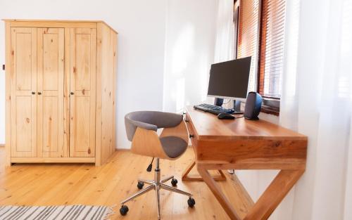 a desk with a computer and a chair in a room at Къща за гости Константин и Елена - гр. Девин in Devin