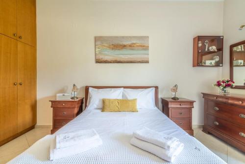 a bedroom with a large bed with two dressers at Vacation House close to the Beach in Elia
