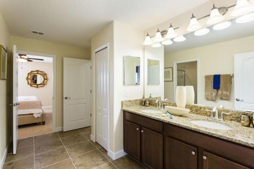 een badkamer met 2 wastafels en een grote spiegel bij Champions Gate Villa CG015 in Davenport