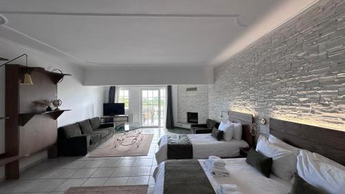 a living room with two beds and a brick wall at Villa Pantheon in Litochoro