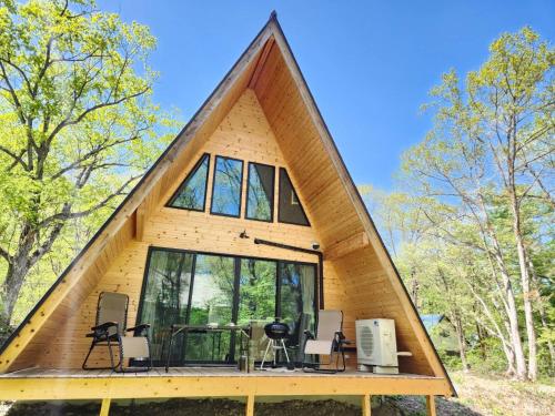 a frame house with a triangular roof at Kitagi Cabin in Hakuba