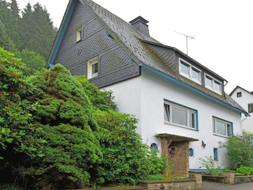 a white house with a black roof at Spacious apartment in Rattlar with private terrace in Willingen