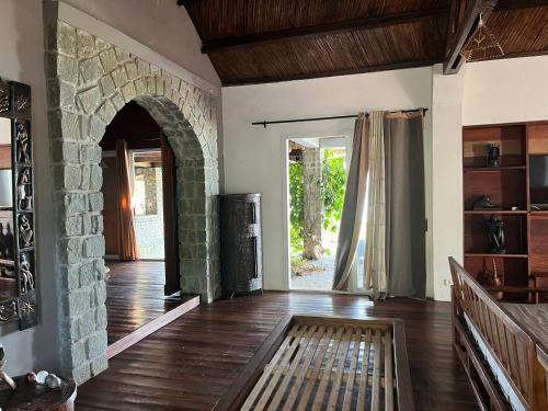 a living room with a stone wall and a wooden floor at blue fenix in Mahavelo