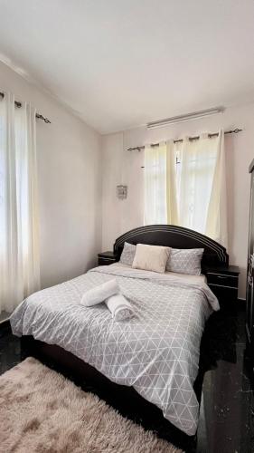 a bedroom with a bed with a black and white comforter at Cozy Apartment with Pool & 10 mins walk to Beach in Mont Choisy