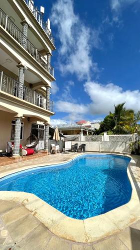 a large swimming pool in front of a building at Cozy Apartment with Pool & 10 mins walk to Beach in Mont Choisy