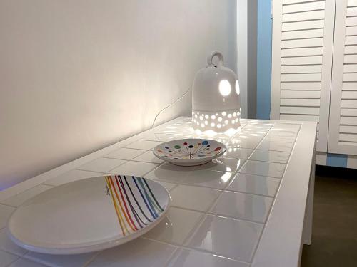 a white table with a bowl and a vase on it at Castello di Granarola Relais - Adults Friendly - in Gradara