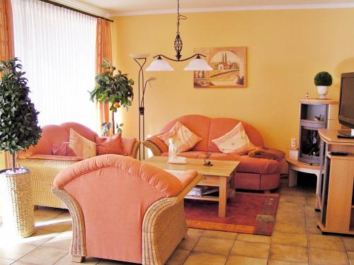 ein Wohnzimmer mit einem Sofa und einem Tisch in der Unterkunft Wellness-Ferienwohnung Strandperle in Cuxhaven