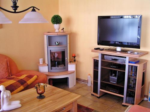 ein Wohnzimmer mit einem Flachbild-TV auf einem Stand in der Unterkunft Wellness-Ferienwohnung Strandperle in Cuxhaven