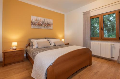 ein Schlafzimmer mit einem großen Bett und einem Fenster in der Unterkunft Villa Tupljak, luxury and comfort in a hidden summer hideout in Gromnik
