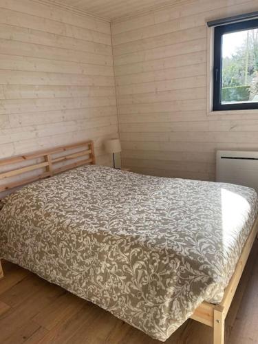 une chambre avec un lit dans une pièce avec une fenêtre dans l'établissement Chalet - Cottage de Lesconil, à Plobannalec-Lesconil