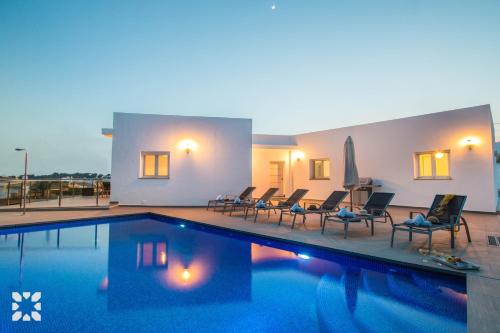 a large swimming pool with chairs and a pool at Villa Baydal by Abahana Villas in Benissa