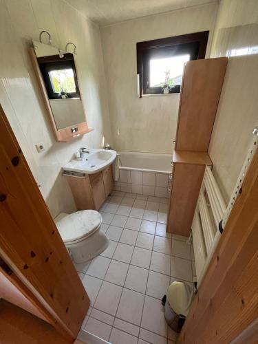 a bathroom with a toilet and a sink and a tub at Ferienhaus am Hennesee in Meschede
