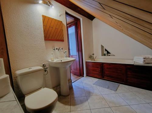 a bathroom with a toilet and a sink and a tub at Apartament Pod Orzechem in Augustów