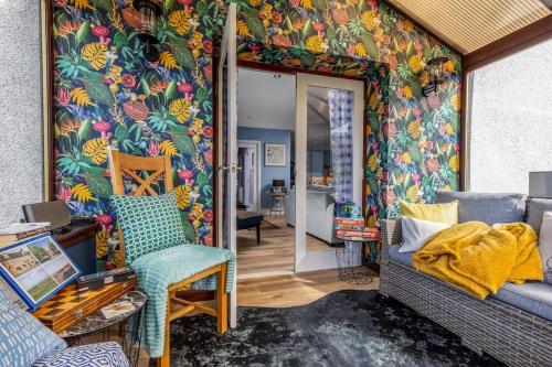a living room with a colorful wall at Orcadia Sutherland Road Dornoch IV25 3SX in Dornoch