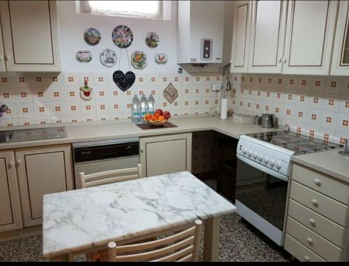 a kitchen with white cabinets and a marble counter top at Vintage Sleep in Rimini