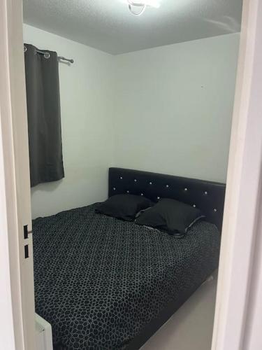 - une chambre avec un lit doté de draps et d'oreillers noirs dans l'établissement Jolie appartement dans résidence avec piscine, à Carnoux-en-Provence