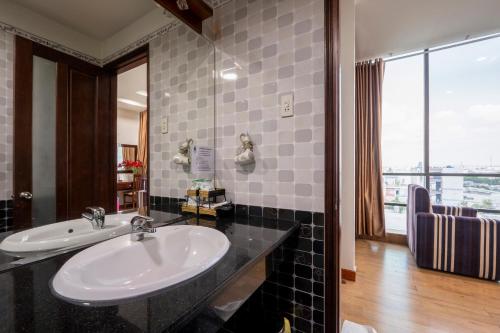 een badkamer met een wastafel en een groot raam bij Thien Phu Logia Hotel in Ho Chi Minh-stad
