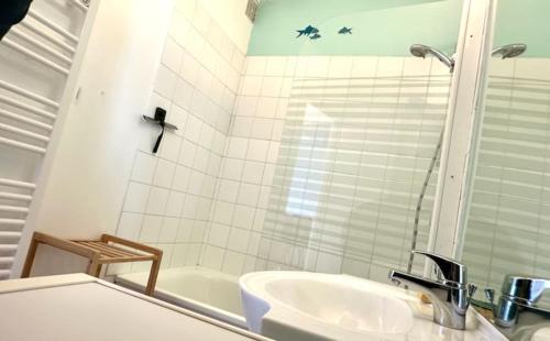 La salle de bains est pourvue d'un lavabo et d'une baignoire. dans l'établissement GOMATH, à Saint-Hilaire-de-Riez