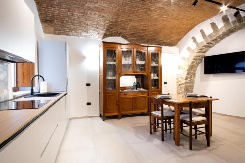 a kitchen with a wooden table and a brick wall at Il Frantoio in Lanusei