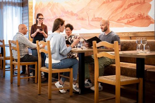 a group of people sitting around a table in a restaurant at Albergo Boschetto Ristorante Pizzeria in Druogno