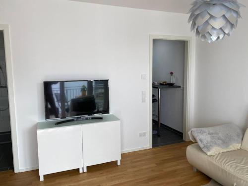 salon z telewizorem na białej szafce w obiekcie Luxus Appartment in Toplage w Hanowerze