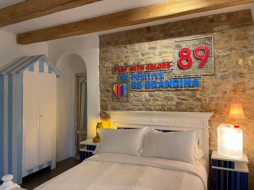 a bedroom with a bed and a stone wall at Castello di Granarola Relais - Adults Friendly - in Gradara