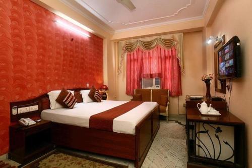 a hotel room with a bed and a television at Hotel Indraprastha in New Delhi