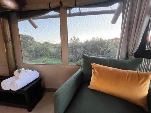 a living room with a green couch and a window at Charihandra Game Lodge in Addo