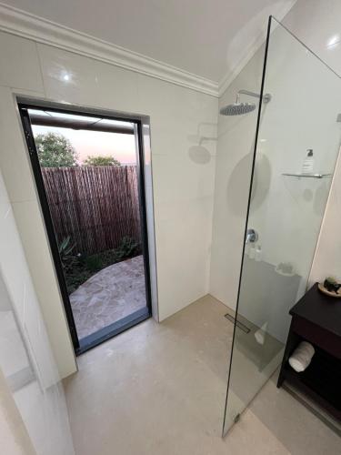a bathroom with a shower and a glass door at Charihandra Game Lodge in Addo