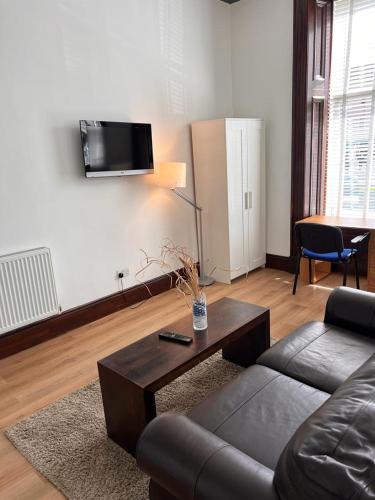 - un salon avec un canapé et une table basse dans l'établissement STUDIO APARTMENT PAISLEY ROAD WEST, à Glasgow