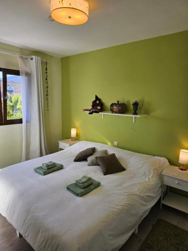 - une chambre avec un grand lit blanc aux murs verts dans l'établissement Casa Los Flamencos, à Monachil